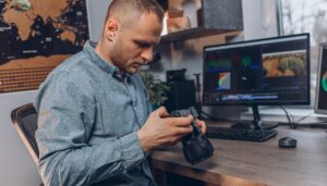 Homme en train de réaliser la post-production d'une photo son écran et appareil